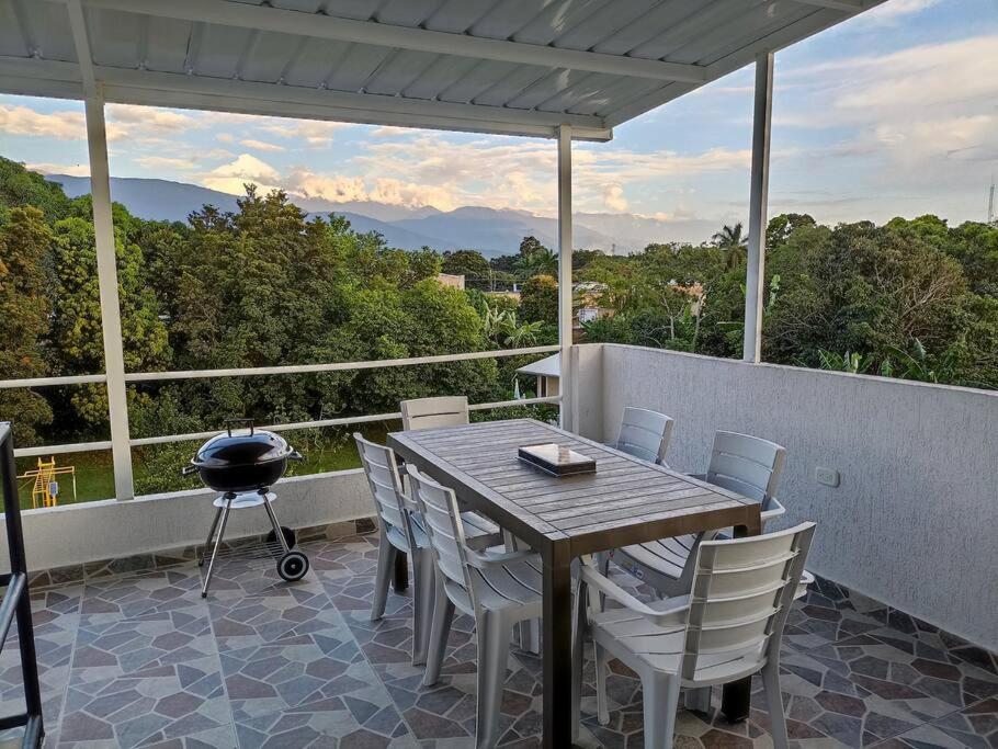 einen Tisch und Stühle auf einem Balkon mit Grill in der Unterkunft Paradisíaco Apt 360º Palmira in Palmira