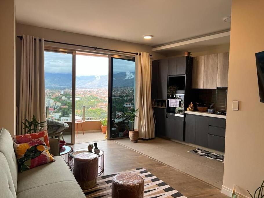 ein Wohnzimmer mit einem Sofa und einem großen Fenster in der Unterkunft Depto a estrenar increíble vista 180º Cocha in Cochabamba