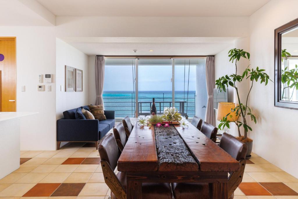 a dining room with a table and a view of the ocean at 海まで徒歩1分 沖縄でも珍しい絶景ホテル 贅沢プライベートビーチ付き ビーチルーム in Onna