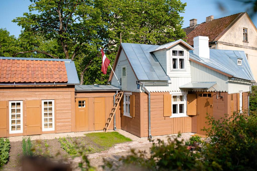 una casa con garaje y una casa con bandera en i’dille Brīvdienu māja, en Kuldīga