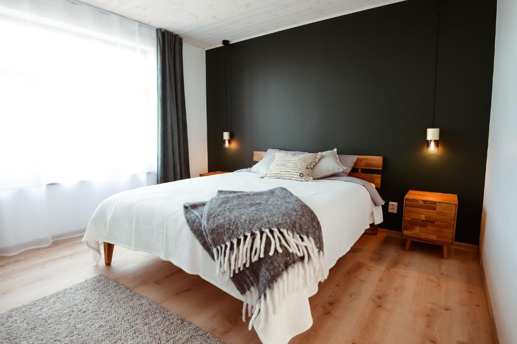 een slaapkamer met een bed en een zwarte muur bij MiMaMo in Põlva