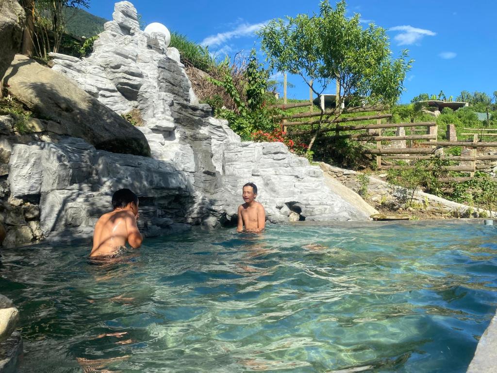 two men in the water at a water slide at Peace Home in Sa Pa