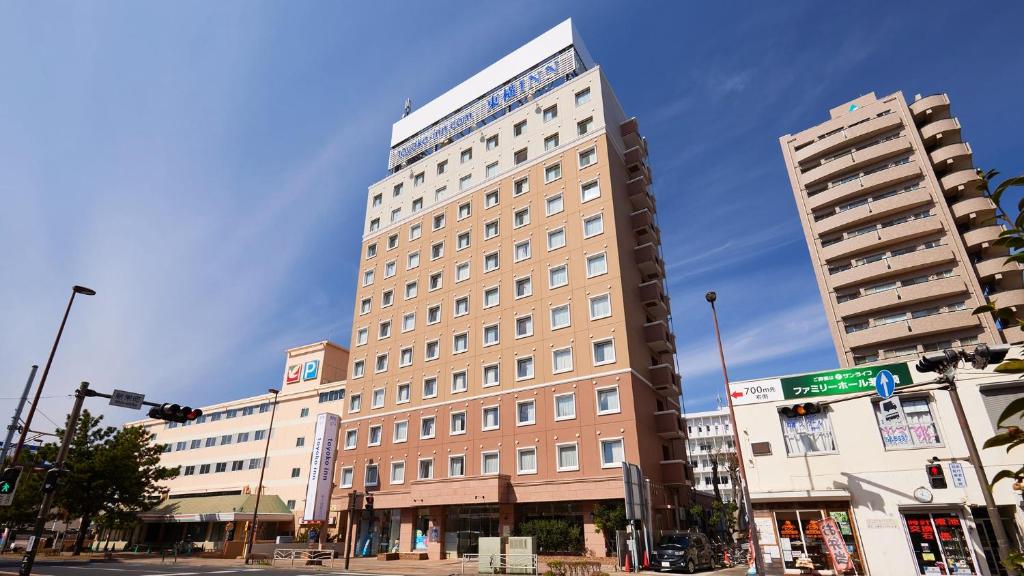 茅崎市Toyoko Inn Shonan Chigasaki eki Kita guchi的街道拐角处的高楼