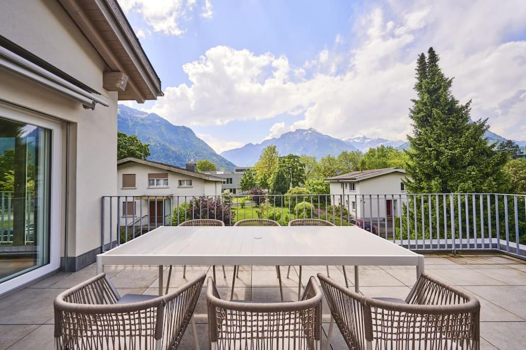 Biały stół i krzesła na patio z górami w obiekcie Terrace Vista Interlaken w mieście Interlaken