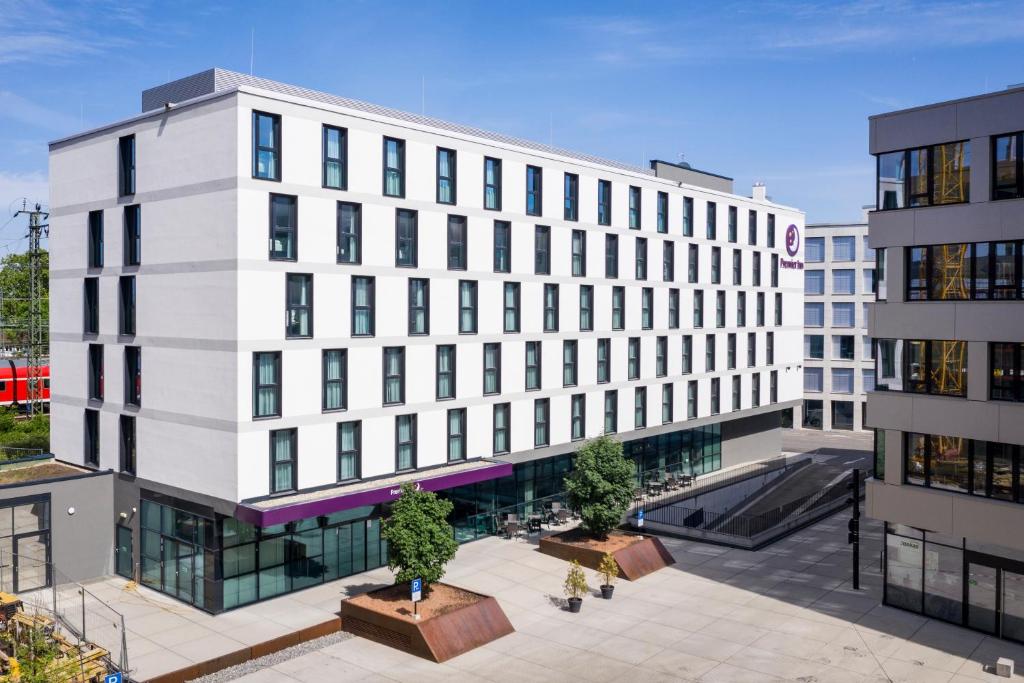 un grande edificio bianco con alberi di fronte di Premier Inn Freiburg City Süd a Friburgo in Brisgovia