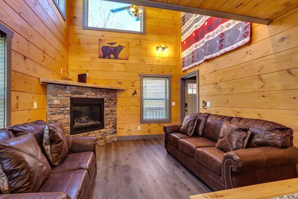 een woonkamer met 2 leren banken en een open haard bij Dancing Bear Cabin- Relax & Enjoy! in Sevierville