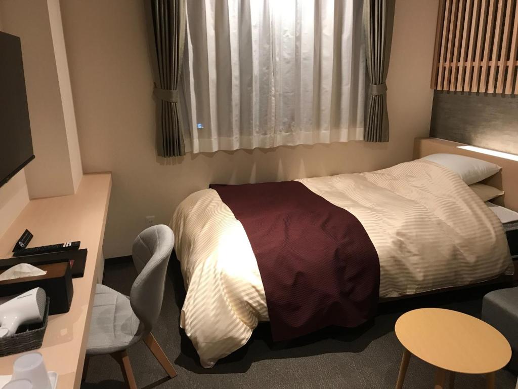 niewielka sypialnia z łóżkiem i krzesłem w obiekcie Aizu Tsuruya Hotel - Vacation STAY 57226v w mieście Aizu-Wakamatsu