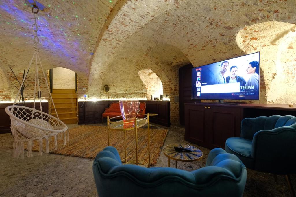 A television and/or entertainment centre at Secret Jacuzzi Mons - Parking privé gratuit