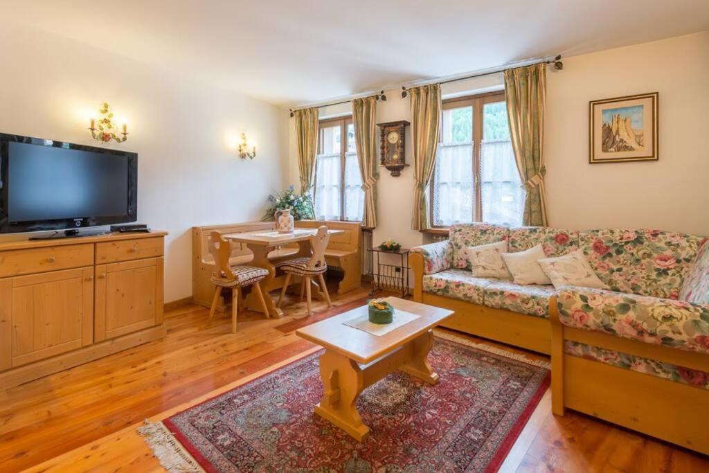 salon z kanapą i stołem w obiekcie Cozy apartment near Cortina w mieście San Vito di Cadore