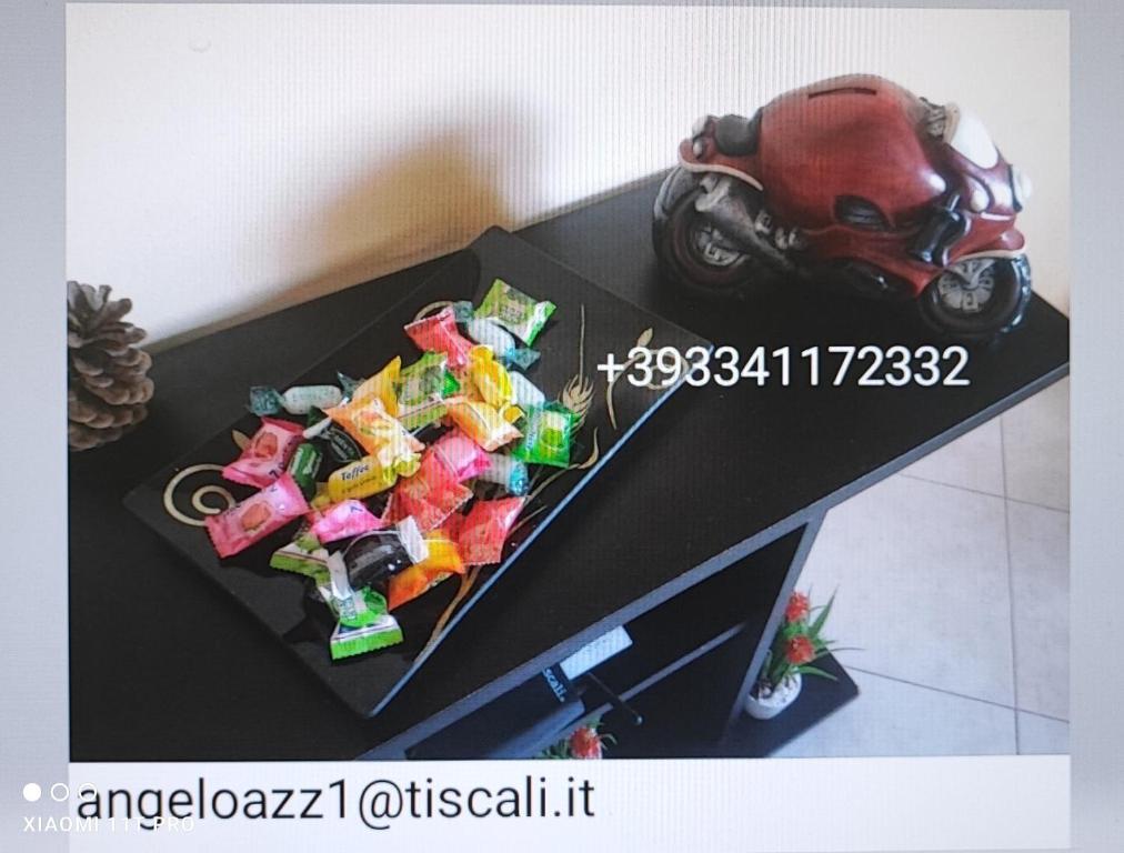 uma mesa com uma moto de brinquedo e doces sobre ela em Sweet Sardinia Apartment R2968 em Elmas