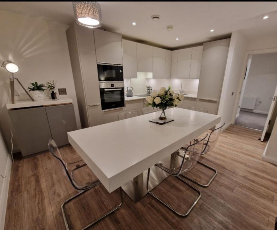 - une cuisine avec une table blanche et des fleurs dans l'établissement Modern apartment, sleeps 6, Belfast city centre, à Belfast