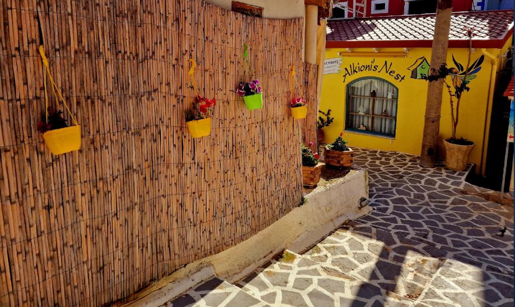 a building with flower pots on a wall at Alkionisnest in Arkoudi