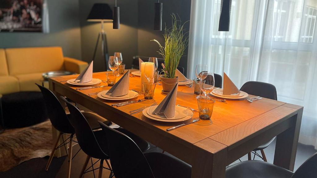 - une longue table en bois avec des verres et des serviettes dans l'établissement InkBlue-Apartment, à Heidenau