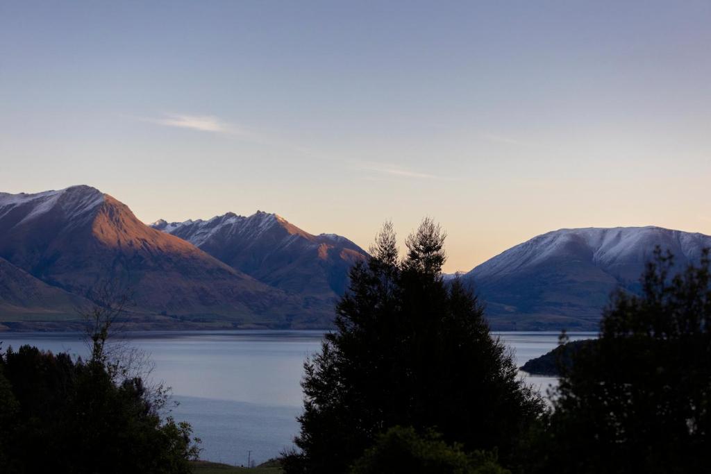 クイーンズタウンにあるKereru Cottage, Romantic & Beautiful Log Cabin - Queenstownの山々を背景にした湖の景色