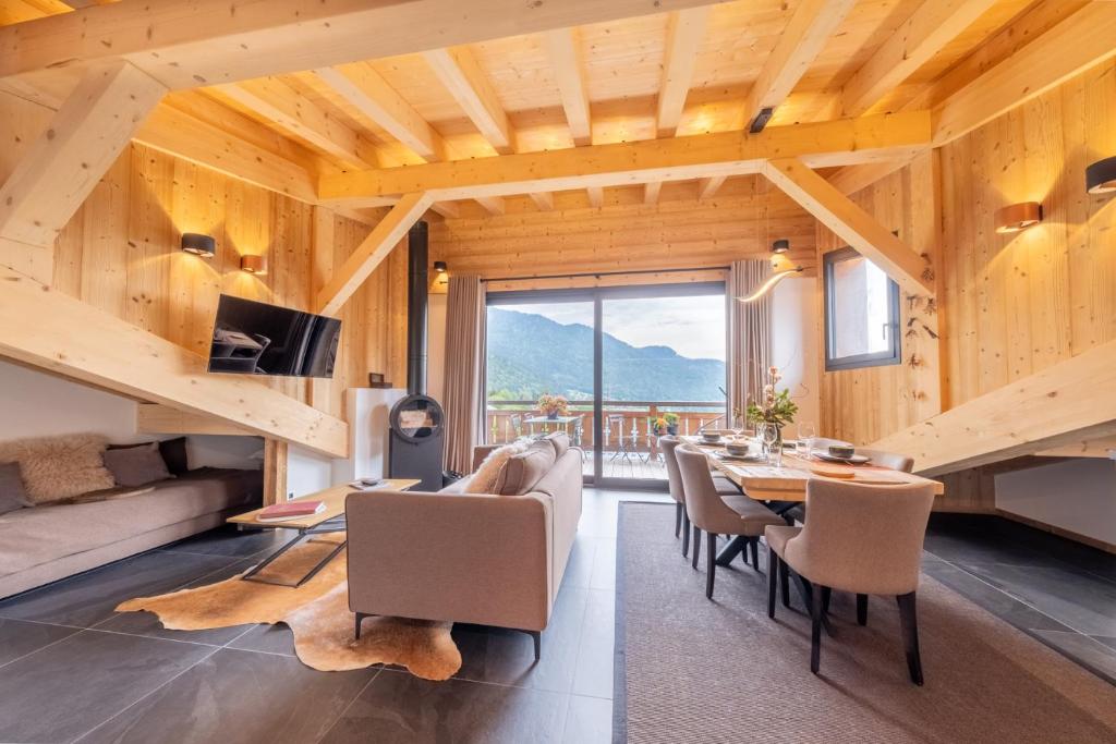 莫尔济讷Appartements Chalet Le Fornay的一间带桌椅和大窗户的用餐室