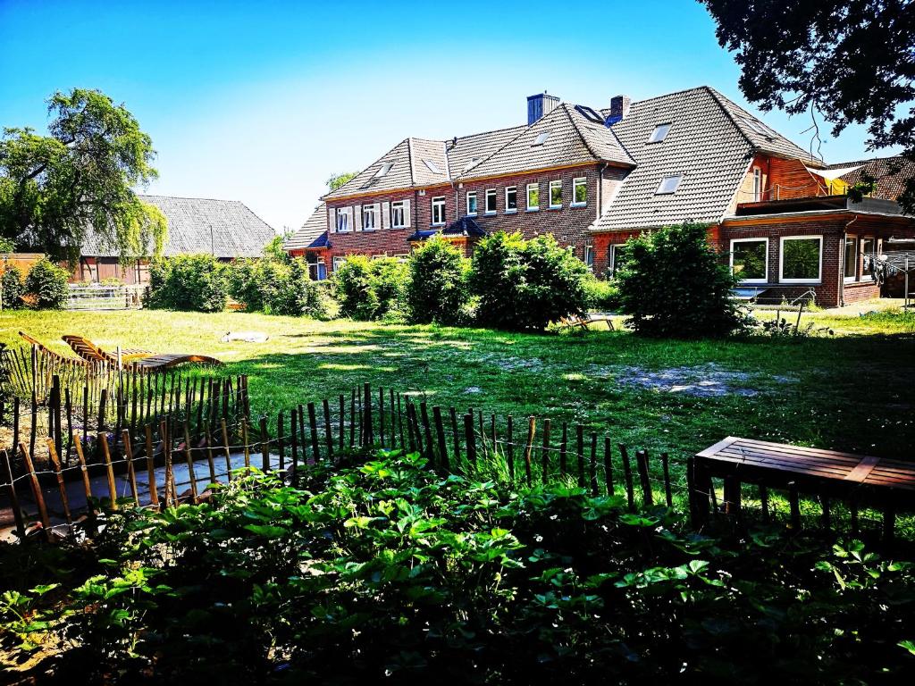 ein Haus mit einem Zaun vor einem Hof in der Unterkunft Gästehaus Maria Rast in Suderburg