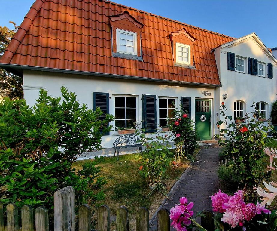 uma casa branca com um telhado laranja e uma cerca em Haus mit 110qm und Garten 150m zum Wasser em Stralsund