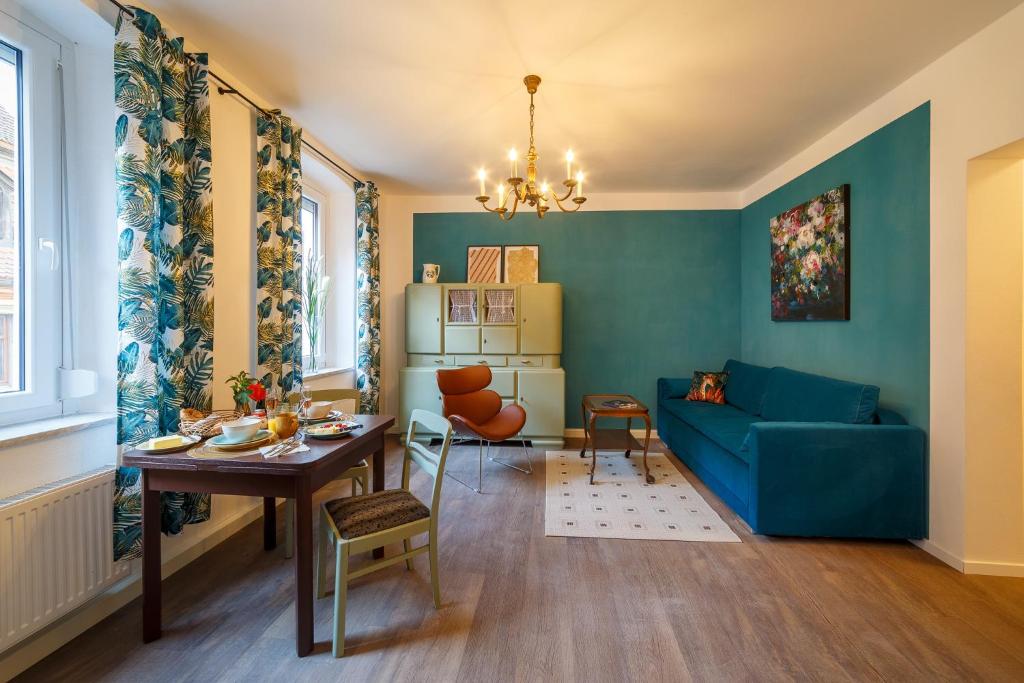 uma sala de estar com um sofá azul e uma mesa em Alte Färberei - Wohnen in der Altstadt em Kulmbach