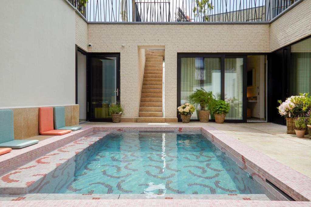 a swimming pool in front of a house at ABC Hotel in Blankenberge