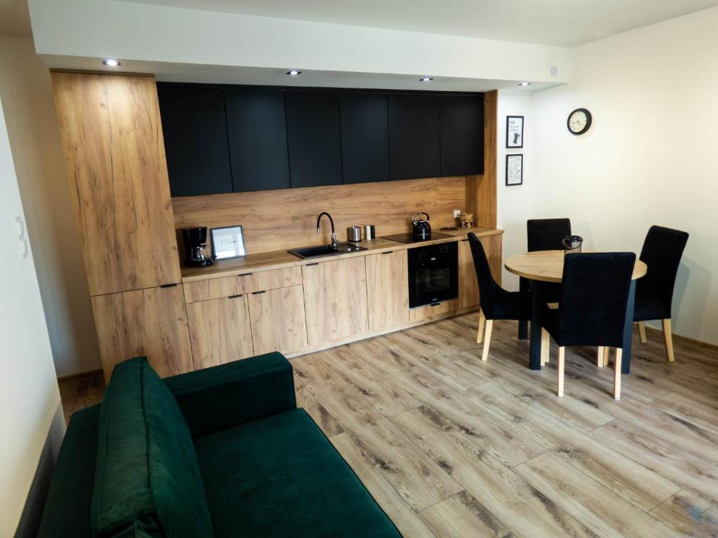 een woonkamer met een bank en een tafel en een keuken bij Apartament Flat 33 Suwałki in Suwałki