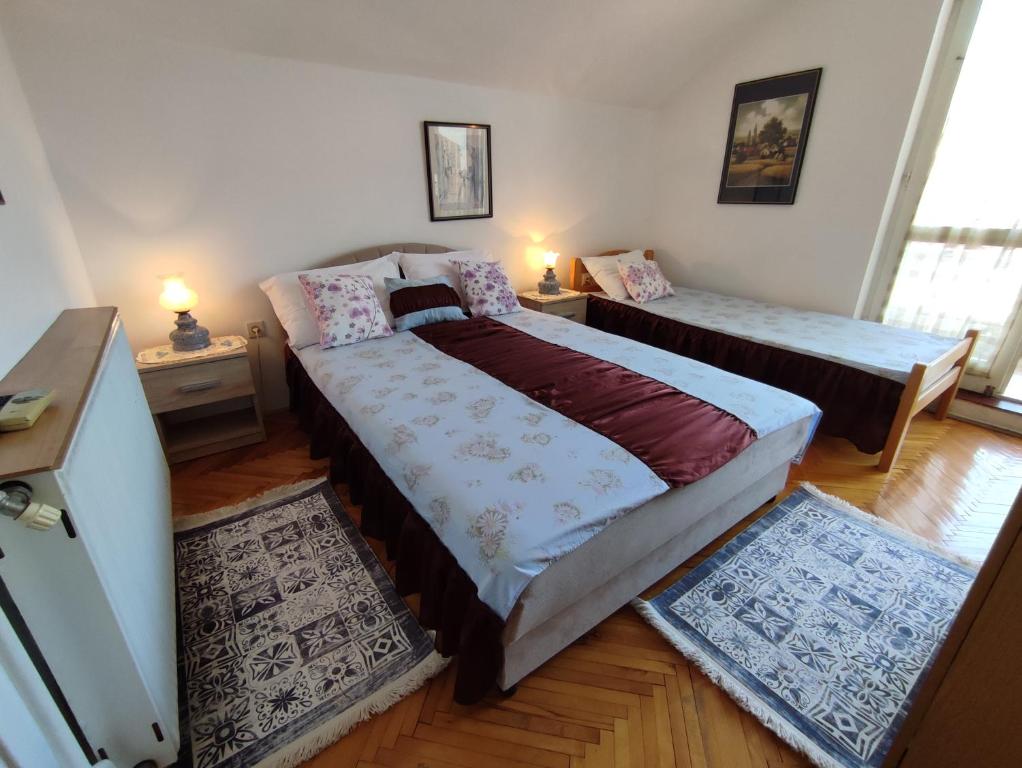 1 dormitorio con 2 camas y 2 alfombras en Smestaj Vella, en Herceg-Novi