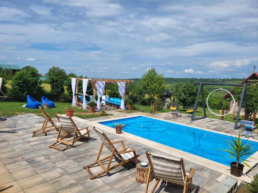 uma piscina com cadeiras e um parque infantil em Vila Stancevic wellness em Sremski Karlovci