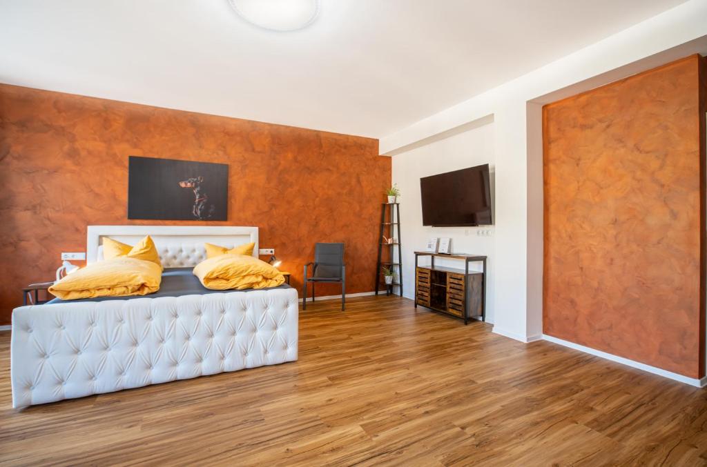 a bedroom with a white bed with yellow pillows at Gwuni Mopera in Leipzig