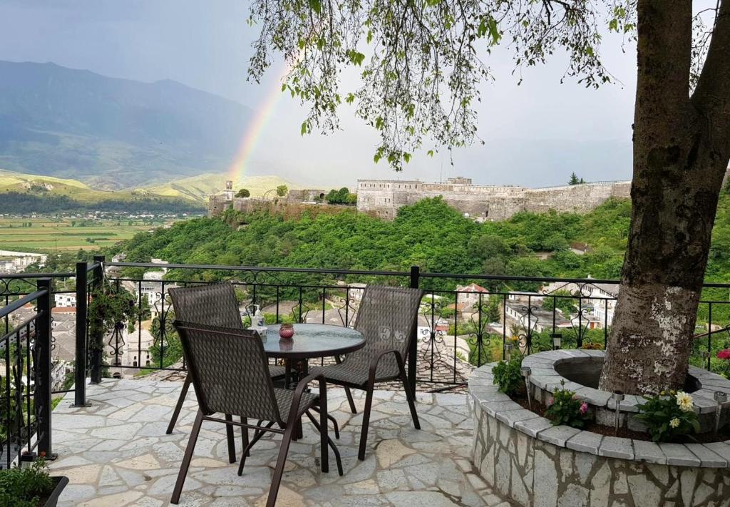 een tafel en stoelen op een patio met een regenboog bij Panoramic Vlachos in Gjirokastër