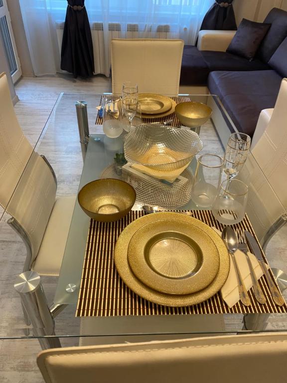 een glazen tafel met gouden platen erop bij Iva Luxury Apartament in Ruse