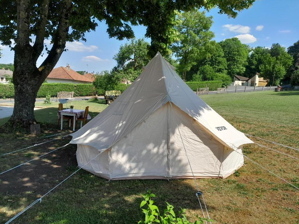 une tente assise sur l'herbe sous un arbre dans l'établissement Le camping du capitaine, à Maranville