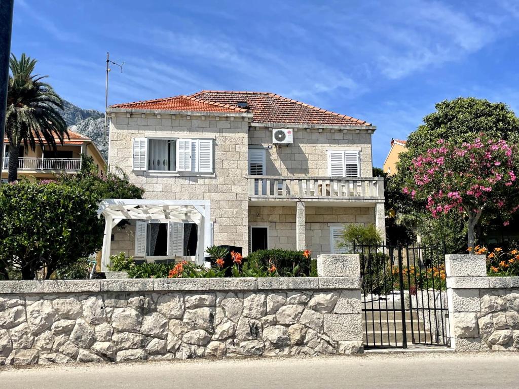 uma casa atrás de uma parede de pedra com uma cerca em Luxury apartment Lukas em Orebić