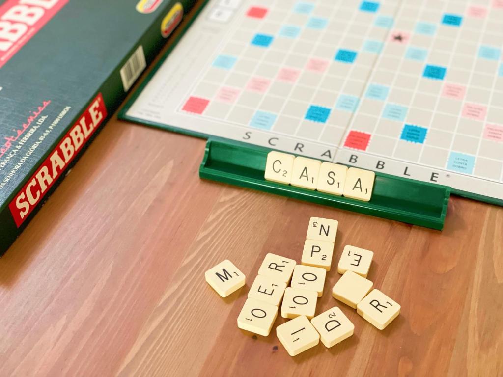 Scrabble board game and a book on a table w obiekcie Casa de Partida w mieście Covilhã