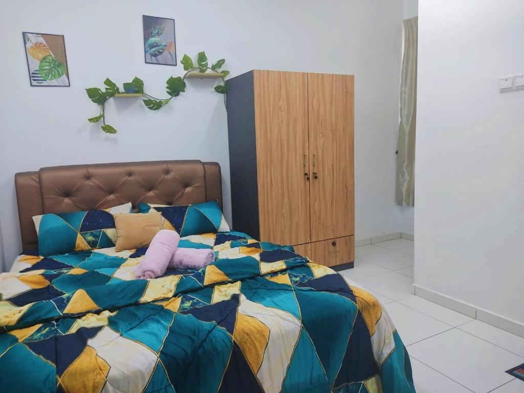 a bedroom with a colorful bed with purple pillows at TOP Muzaffar Homestay in Ayer Keroh