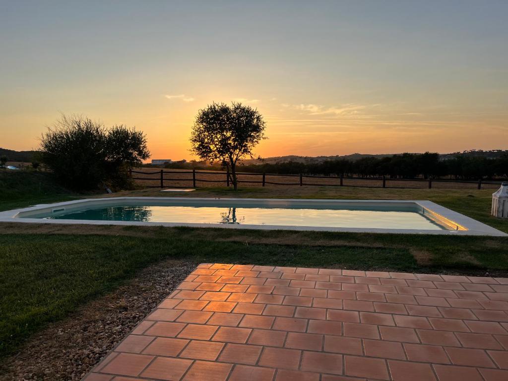 una piscina en el césped con una puesta de sol en el fondo en Casa Bendi, en Cuba