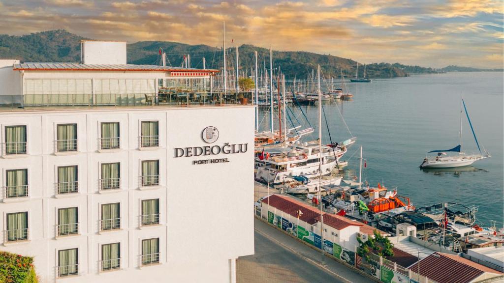 フェティエにあるDedeoğlu Port Hotelの水上の船が浮かぶマリーナの隣の建物