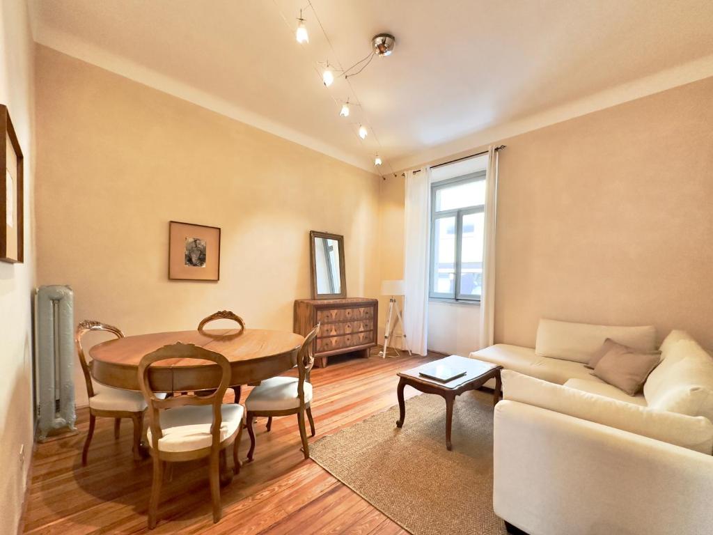 uma sala de estar com uma mesa e um sofá em Suite Cavour by iCasamia it em Varese