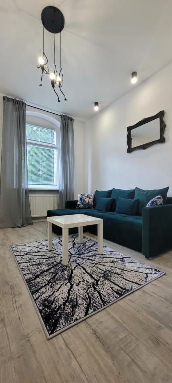 uma sala de estar com um sofá e uma mesa em Apartament CityStation em Wałbrzych