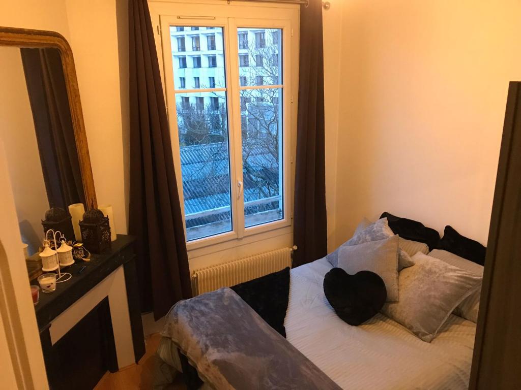 Un pat sau paturi într-o cameră la Appartement 60 m², porte de Saint-Cloud