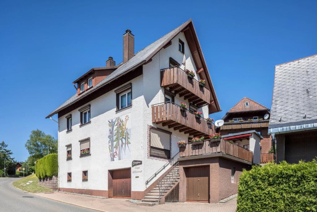 um edifício branco com varandas de madeira numa rua em Waldesruh em Titisee-Neustadt