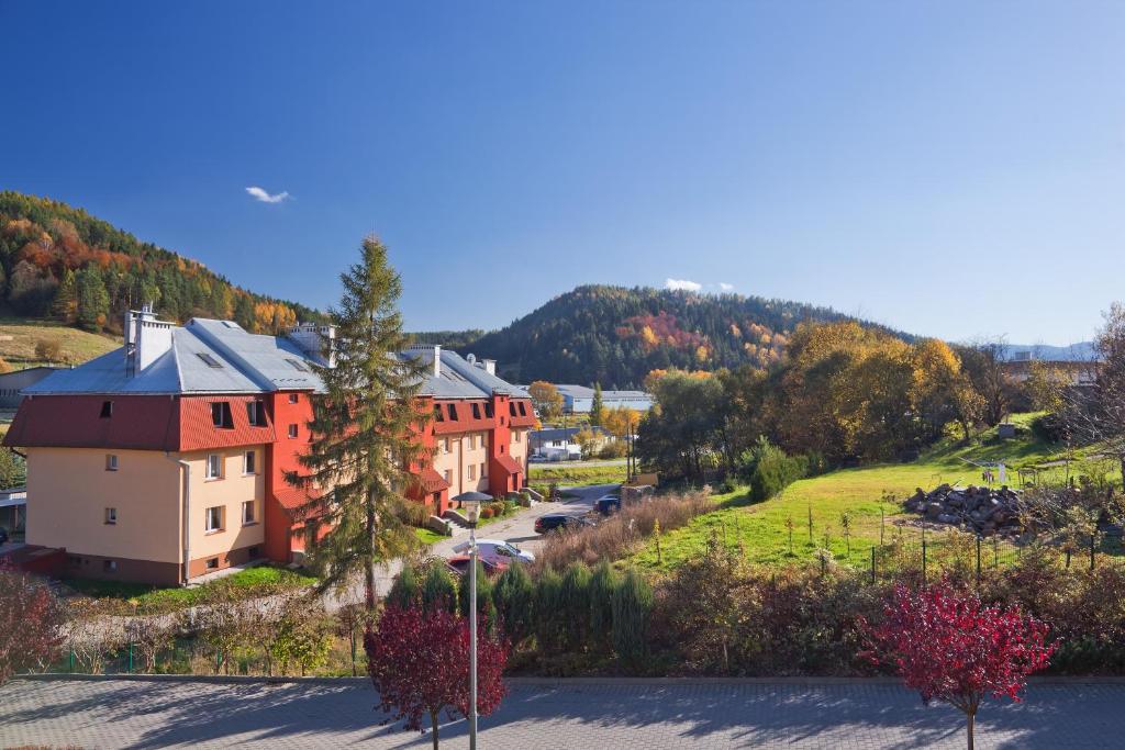 una fila di case su una collina con una montagna di PRESTIGE PARK apartament z tarasem i parkingiem a Krynica-Zdrój