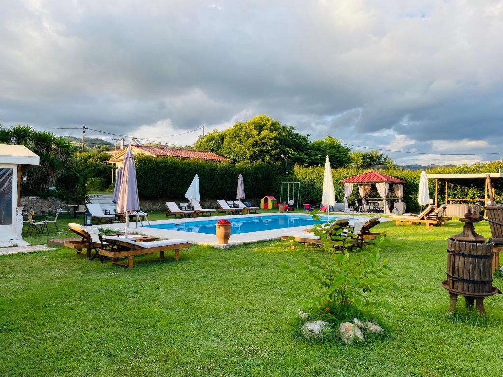 een zwembad in een tuin met stoelen en parasols bij THE MANSION OF DIONISOS AND DIMITRAS 2 in Olympia