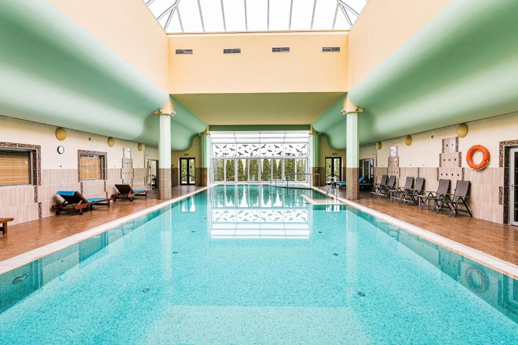 - une grande piscine dans un bâtiment doté d'un plafond dans l'établissement Hotel Savannah, à Chvalovice