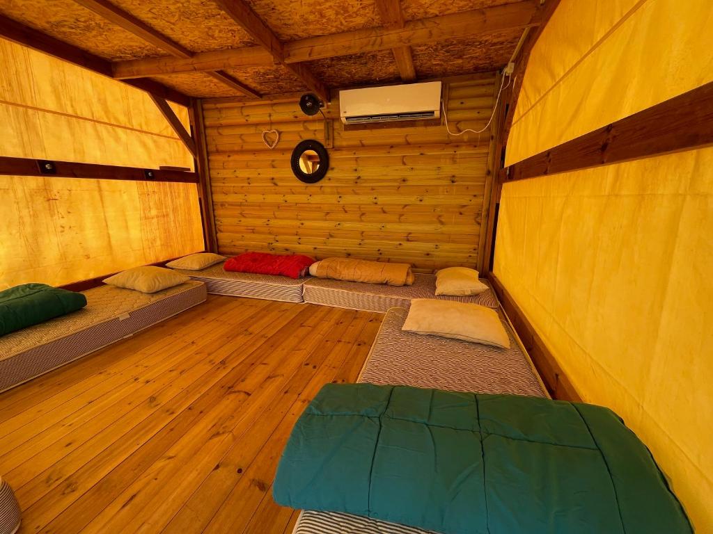 um quarto com 4 camas num quarto de madeira em Ein Gedi Camp Lodge em Ein Gedi