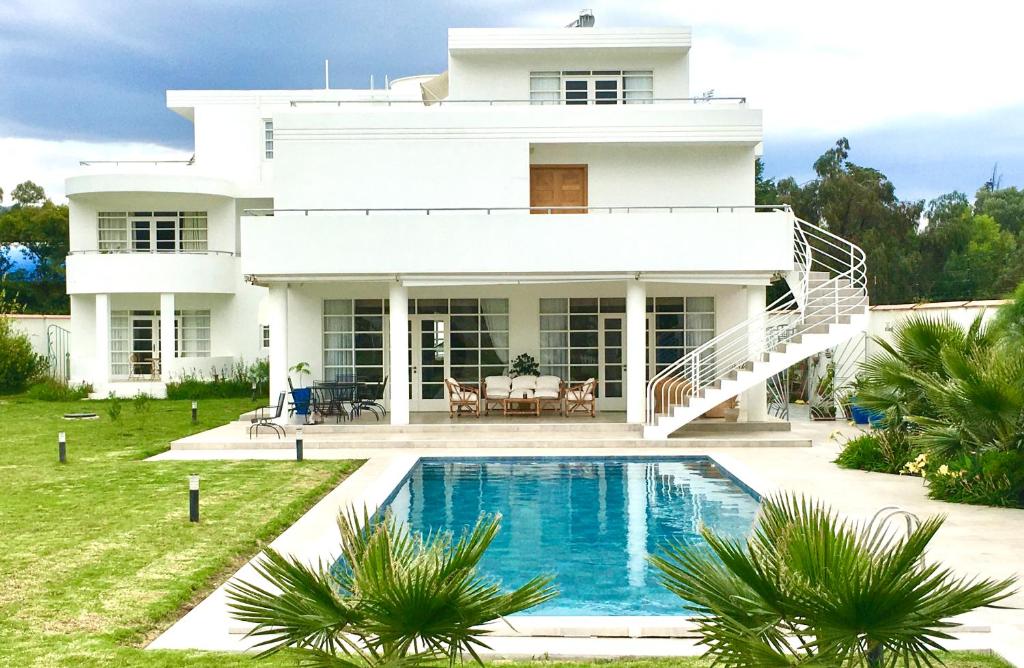 ein weißes Haus mit einem Pool davor in der Unterkunft Casa Deco Hotel Boutique in Cochabamba