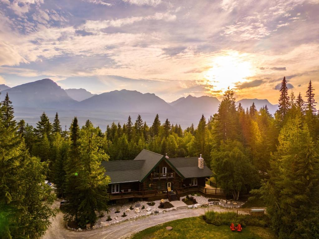 a log cabin in the woods with the sun setting at Moberly Lodge in Golden