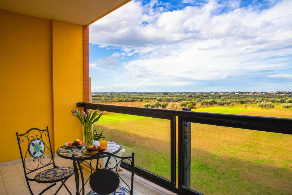 een balkon met een tafel en stoelen en uitzicht op een veld bij Hotel Residence Federiciano in Valenzano