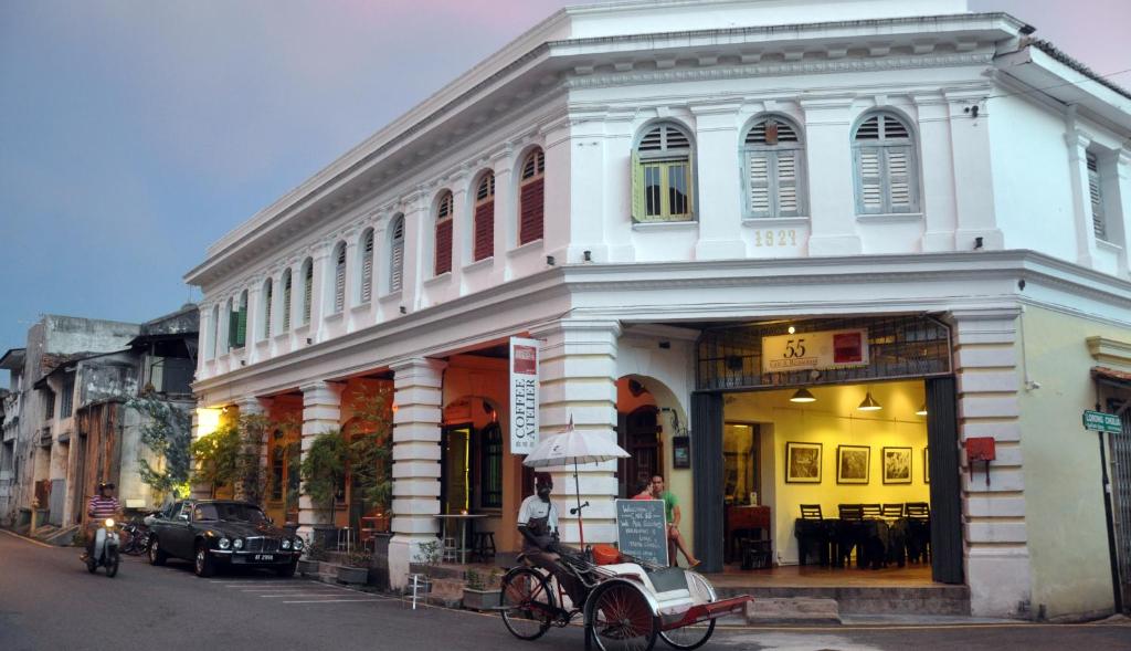 un edificio bianco con una bicicletta parcheggiata di fronte di Coffee Atelier a George Town