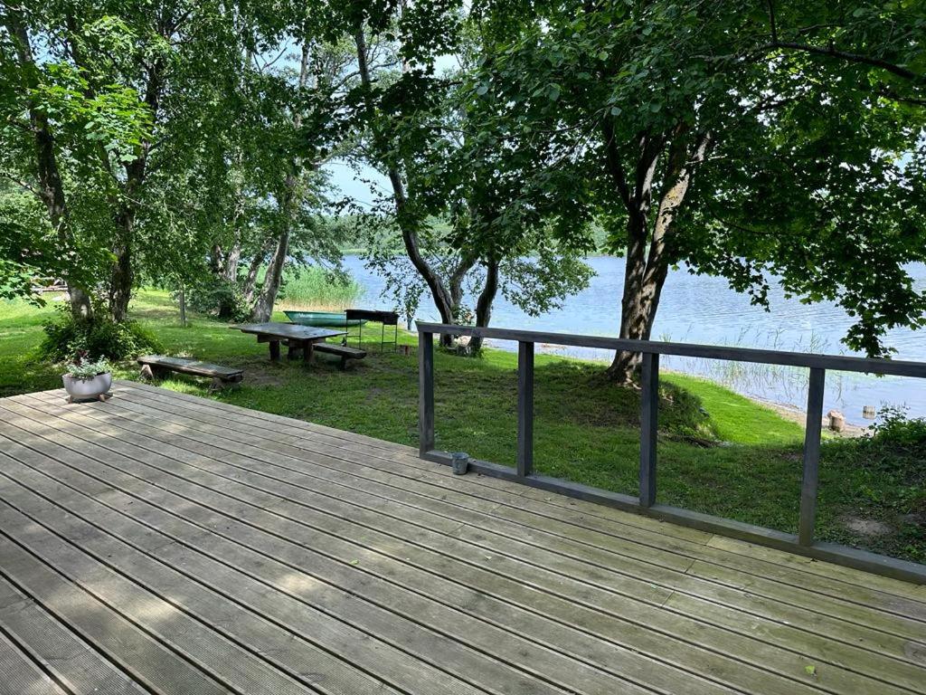 a wooden deck with a fence and a picnic table at Vecliepas in Vārve