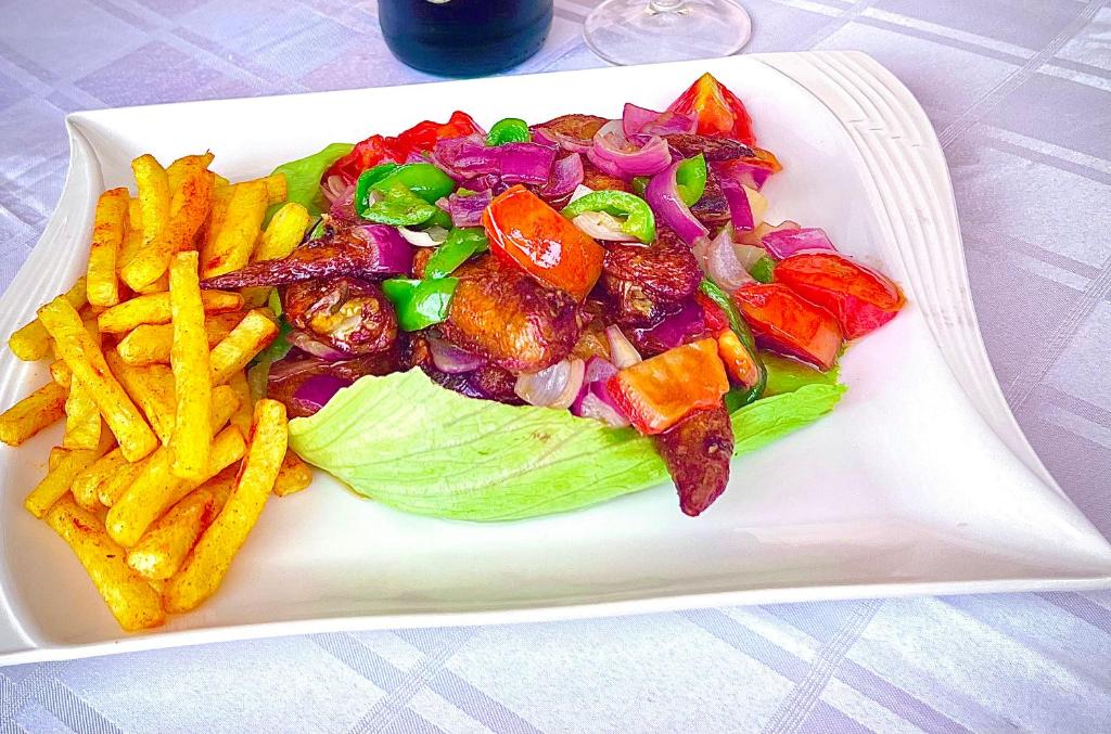 um prato de comida com salada e batatas fritas em Trendy apartments em Entebbe