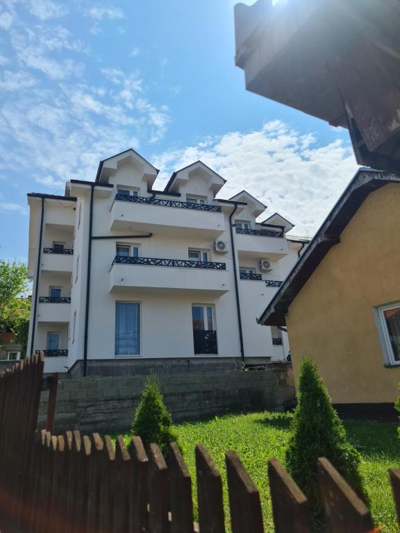 un bâtiment blanc avec une clôture devant lui dans l'établissement Vila Sunset, à Sokobanja